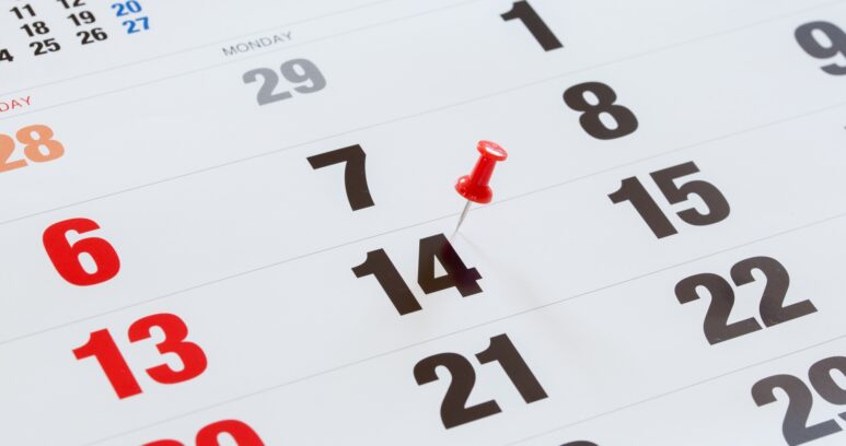 Pin pushed on a calendar concept for an important day.
