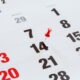 Pin pushed on a calendar concept for an important day.